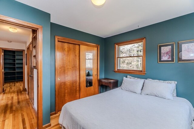 bedroom featuring light wood-type flooring, a closet, and baseboards