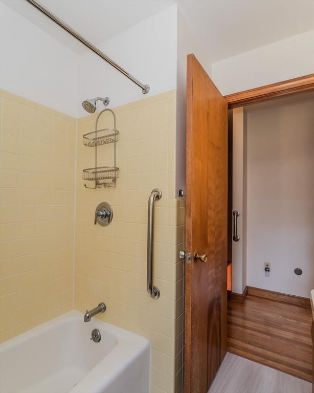 full bath with baseboards, shower / bathtub combination, and wood finished floors