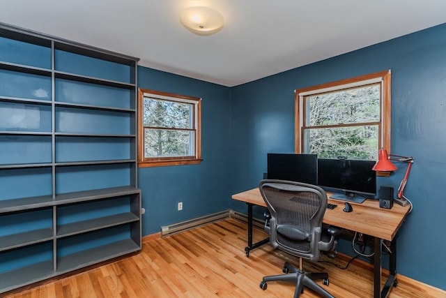 office area with a baseboard heating unit, baseboards, and wood finished floors