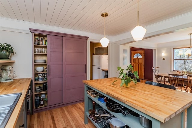 kitchen with open shelves, a sink, wood counters, light wood-style floors, and freestanding refrigerator