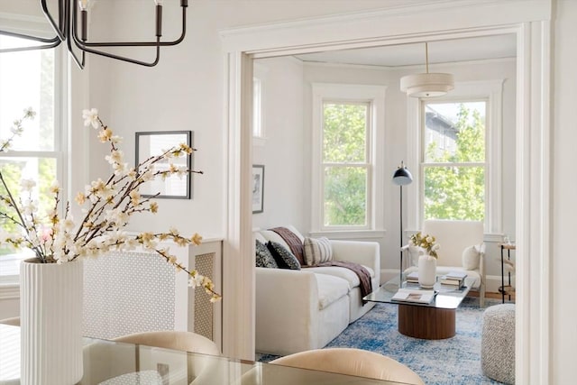 living area with a chandelier and ornamental molding