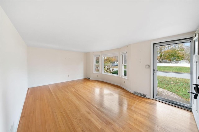 interior space featuring baseboards, visible vents, and light wood-style floors