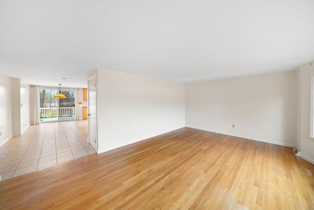 empty room with light wood finished floors and baseboards