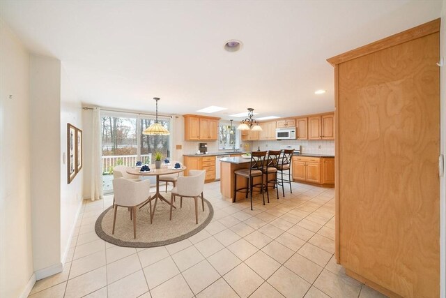 dining space with light tile patterned floors, recessed lighting, and baseboards