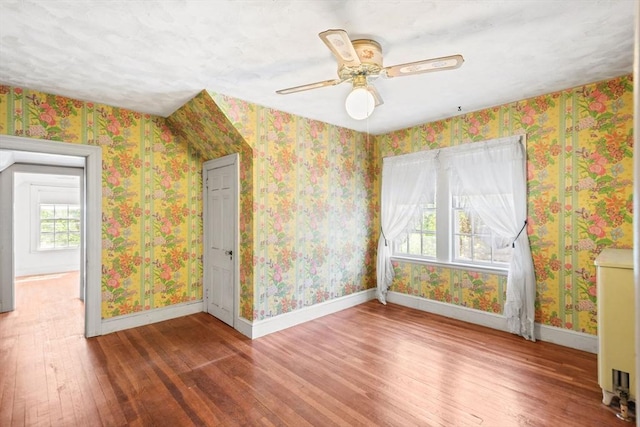 bonus room with wood-type flooring, baseboards, and ceiling fan