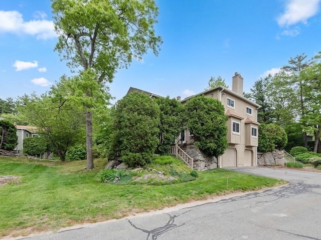 3 Loyalist Dr Unit 3, Uxbridge, MA 01569 - view of front of house featuring an attached garage, driveway, a chimney, a front lawn, and stairs