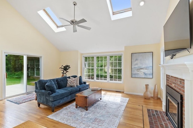 31 Fort Pond Hill Rd, Littleton, MA 01460 - living area featuring a skylight, a fireplace, light wood finished floors, high vaulted ceiling, and ceiling fan