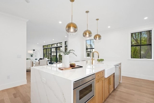 kitchen featuring baseboards, recessed lighting, a sink, light wood-style flooring, and appliances with stainless steel finishes