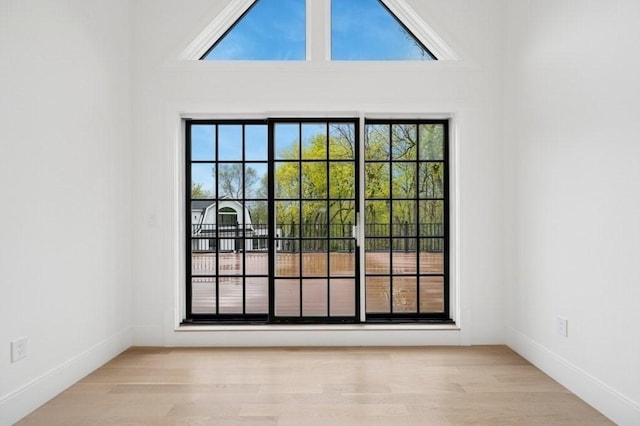 doorway to outside with plenty of natural light, baseboards, and wood finished floors