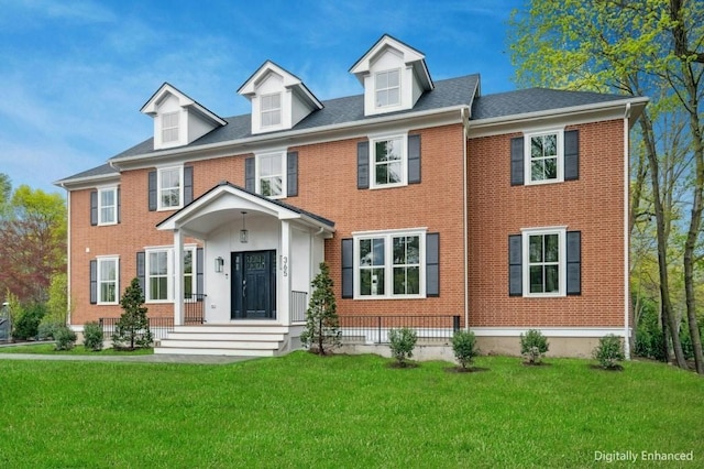 view of front facade featuring brick siding and a front yard