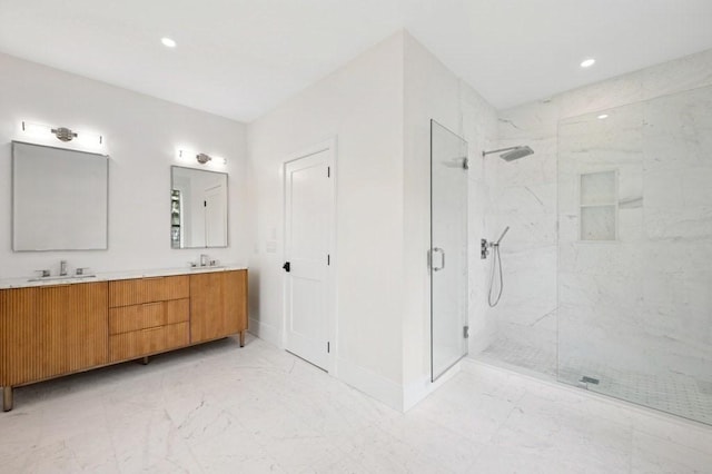full bath with baseboards, double vanity, marble finish floor, and a marble finish shower