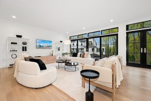 living area with light wood-style floors, crown molding, french doors, and recessed lighting
