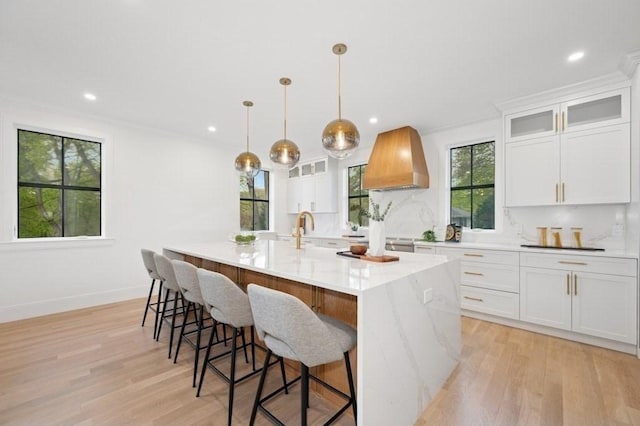 kitchen featuring light wood-style floors, plenty of natural light, and premium range hood
