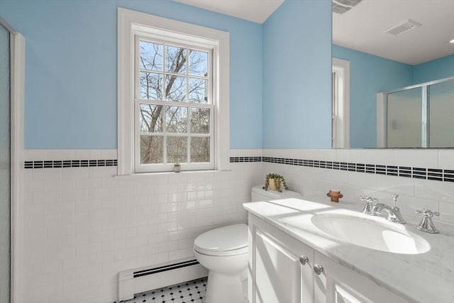 bathroom with visible vents, toilet, a stall shower, tile walls, and baseboard heating