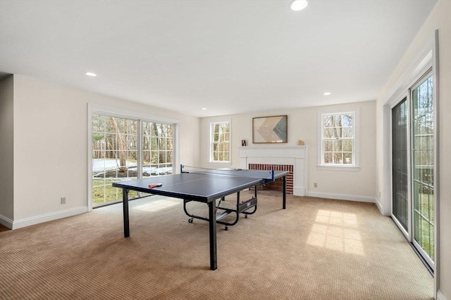 rec room with recessed lighting, a fireplace, baseboards, and light carpet