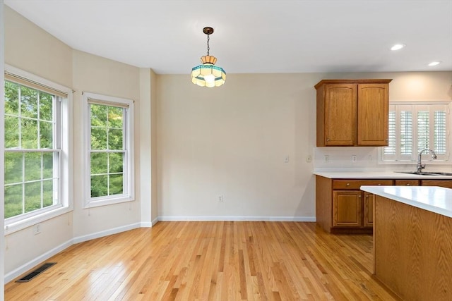 49 Champlain Cir, Plymouth, MA 02360 - kitchen featuring light wood-type flooring, light countertops, brown cabinetry, plenty of natural light, and recessed lighting