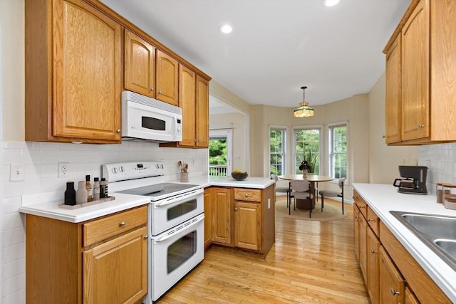 49 Champlain Cir, Plymouth, MA 02360 - kitchen with white appliances, light wood-type flooring, tasteful backsplash, light countertops, and decorative light fixtures