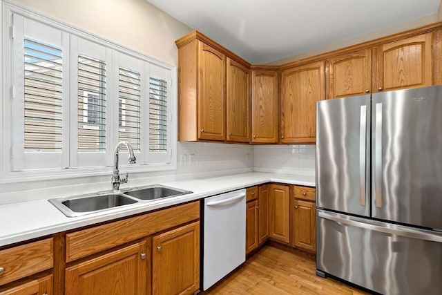 49 Champlain Cir, Plymouth, MA 02360 - kitchen with freestanding refrigerator, dishwasher, light countertops, brown cabinetry, and light wood-style flooring