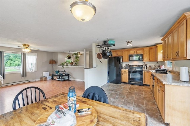 415 Holtshire Rd, Orange, MA 01364 - kitchen with black appliances, a baseboard heating unit, light countertops, a ceiling fan, and baseboards