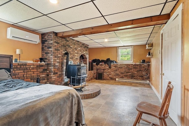 415 Holtshire Rd, Orange, MA 01364 - bedroom featuring a wall mounted air conditioner, a wood stove, brick wall, a baseboard radiator, and a paneled ceiling