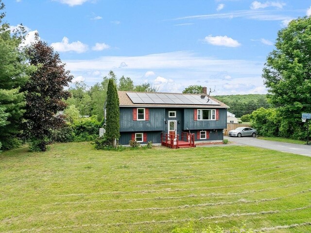415 Holtshire Rd, Orange, MA 01364 - raised ranch with solar panels, a chimney, and a front lawn