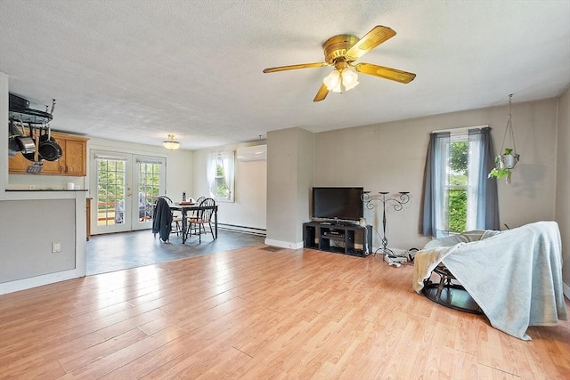 415 Holtshire Rd, Orange, MA 01364 - living area with a wall mounted air conditioner, ceiling fan, light wood finished floors, a baseboard radiator, and a textured ceiling