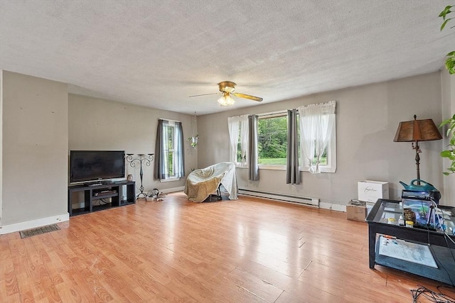 415 Holtshire Rd, Orange, MA 01364 - living room featuring a baseboard radiator, a textured ceiling, light wood-type flooring, a ceiling fan, and baseboards