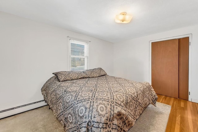 bedroom featuring light wood-style floors and baseboard heating