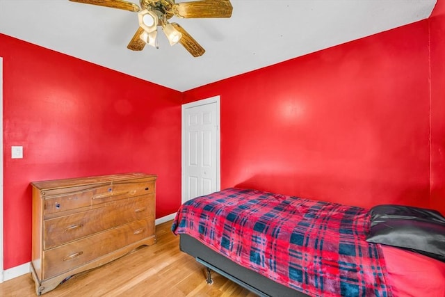 bedroom featuring a ceiling fan, baseboards, and wood finished floors