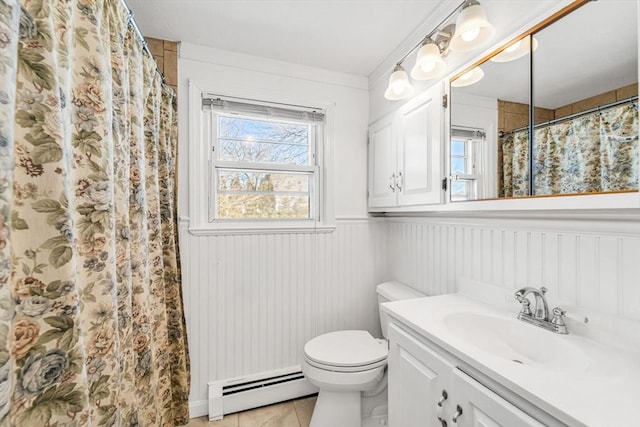 bathroom with a wainscoted wall, a baseboard radiator, toilet, vanity, and tile patterned flooring