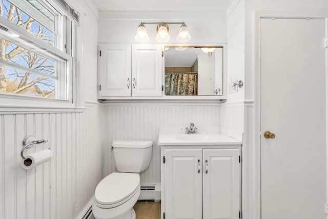 full bath with a wainscoted wall, crown molding, toilet, baseboard heating, and vanity