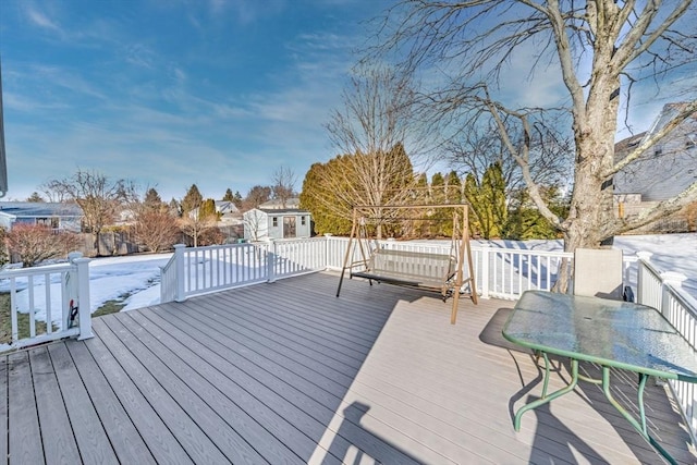 wooden terrace featuring a shed, an outdoor structure, and outdoor dining space