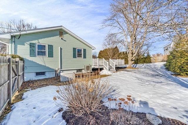 snow covered property featuring fence and a wooden deck