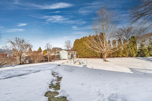 snowy yard with an outbuilding and a storage unit