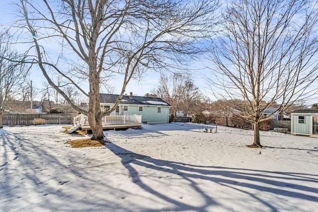 exterior space featuring an outbuilding, a storage shed, a deck, and fence