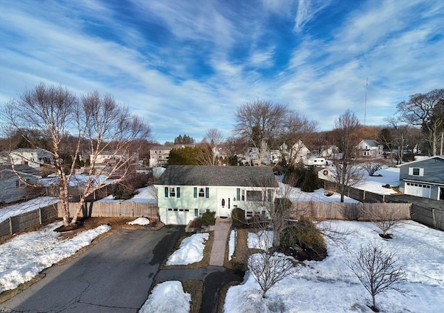 view of front of property featuring a residential view, fence, and driveway