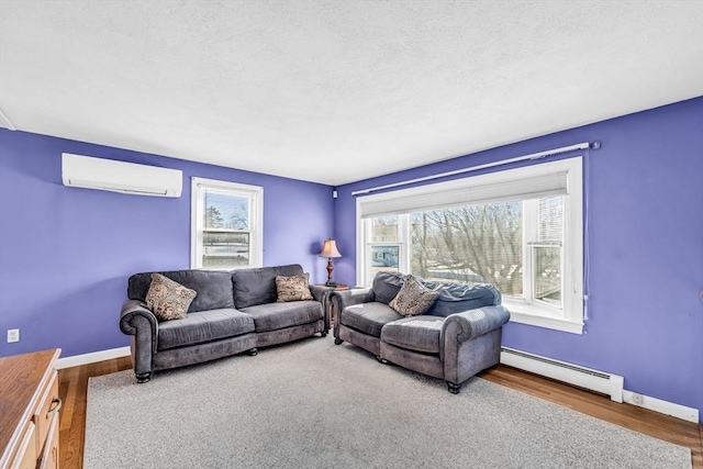 living area with baseboards, a baseboard heating unit, wood finished floors, and a wall mounted AC