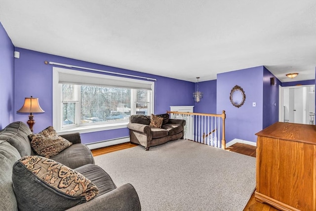 living area featuring baseboards, baseboard heating, and wood finished floors