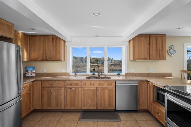 kitchen with brown cabinets, light tile patterned floors, recessed lighting, appliances with stainless steel finishes, and a sink