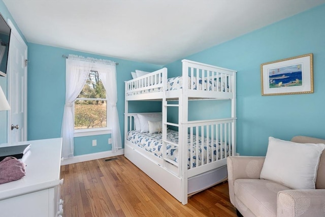 bedroom featuring hardwood / wood-style floors and baseboards