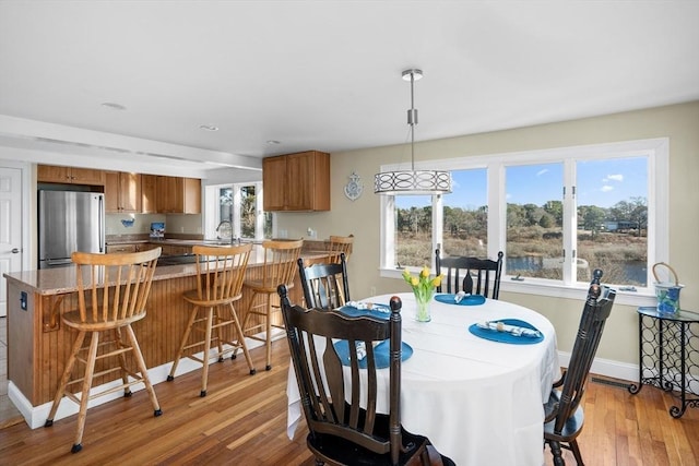 dining room with light wood finished floors and baseboards