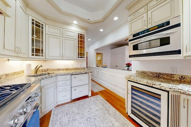 15 Garrison Rd, Brookline, MA 02445 - kitchen featuring wine cooler, appliances with stainless steel finishes, light wood finished floors, a sink, and recessed lighting