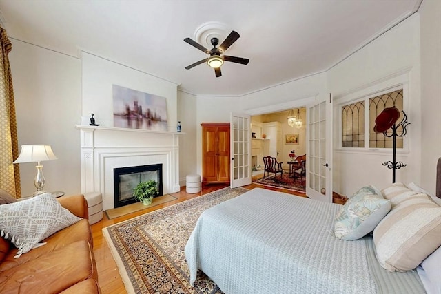 15 Garrison Rd, Brookline, MA 02445 - bedroom with french doors, wood finished floors, a glass covered fireplace, and ceiling fan