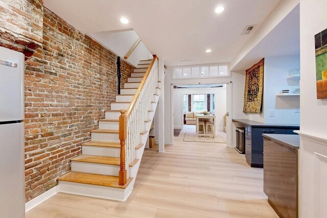 15 Garrison Rd, Brookline, MA 02445 - staircase with wood finished floors, baseboards, brick wall, and recessed lighting