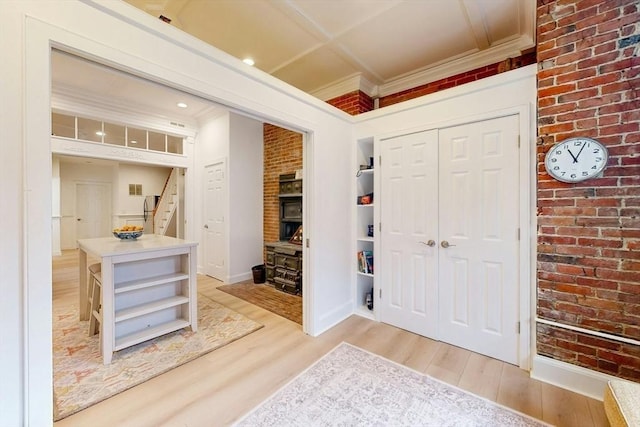 15 Garrison Rd, Brookline, MA 02445 - foyer entrance featuring light wood-type flooring, crown molding, baseboards, stairway, and brick wall