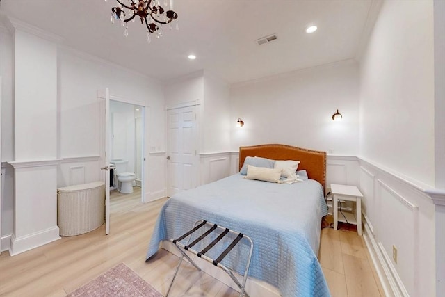 15 Garrison Rd, Brookline, MA 02445 - bedroom featuring a decorative wall, a chandelier, ornamental molding, connected bathroom, and light wood finished floors