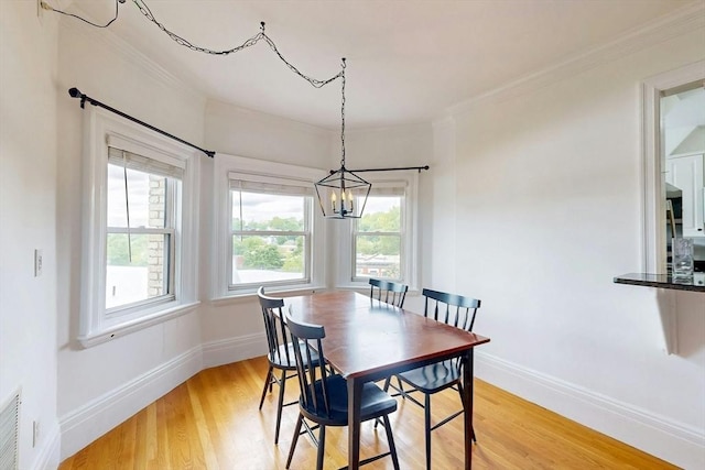 15 Garrison Rd, Brookline, MA 02445 - dining area with a chandelier, crown molding, light wood-style flooring, and baseboards