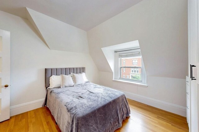15 Garrison Rd, Brookline, MA 02445 - bedroom featuring wood finished floors, lofted ceiling, and baseboards