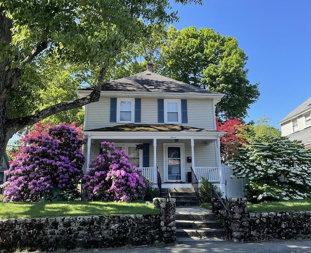 traditional style home with a chimney and covered porch