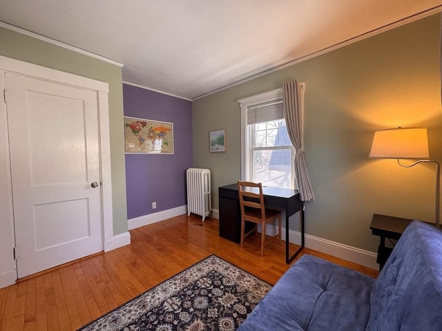 home office featuring radiator, crown molding, wood finished floors, and baseboards